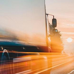 An image of a truck heading into the sunset.